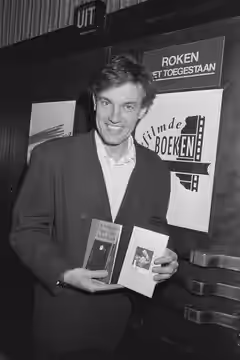 Collectie / Archief : Fotocollectie Anefo Reportage / Serie : [ onbekend ] Beschrijving : Acteur Derek de Lint krijgt het eerste exemplaar van het Boekenweekges (1989)