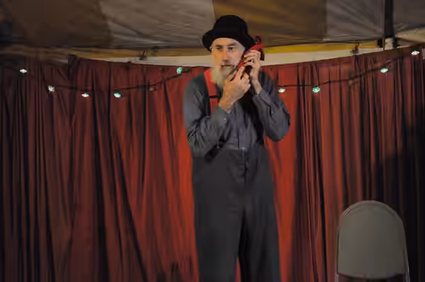 Avner the Eccentric (Avner Eisenberg) performing at Chumleighland, Camano Island, Washington, USA. In this routine, Avner makes a twisted cloth napkin appear to (2009)