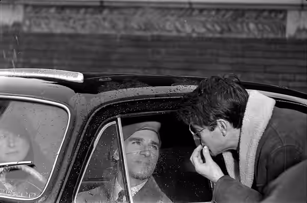 Quartier Saint-Sernin. Le 2 novembre 1965. Plan rapproché de l'acteur Jean Poiret dans une voiture regardant par la fenètre le réalisateur de profil, lors d'une