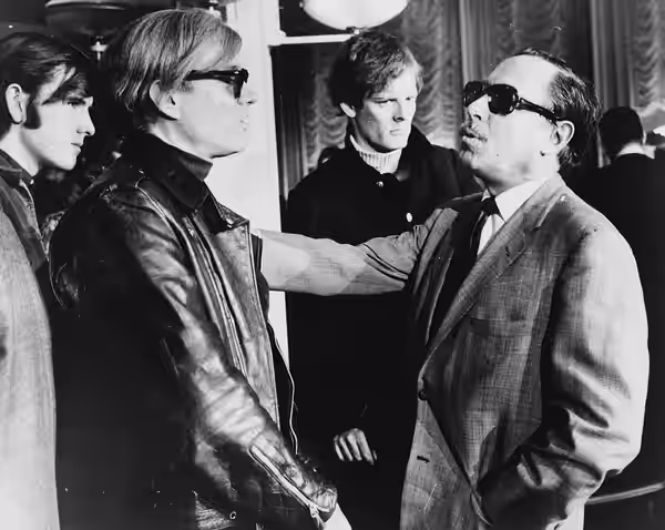 Andy Warhol (left) and Tennessee Williams (right) talking on the SS France, in the background: Paul Morrissey. (1967)