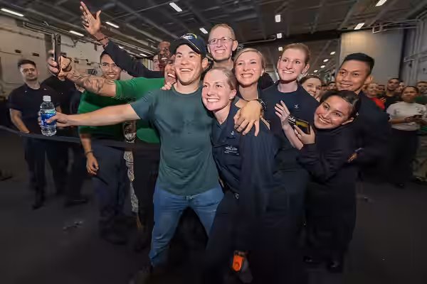 ARABIAN GULF (Dec. 23, 2017) Actor and comedian, Adam Devine takes a photo with Sailors during a USO-sponsored visit aboard the aircraft carrier USS Theodore Ro