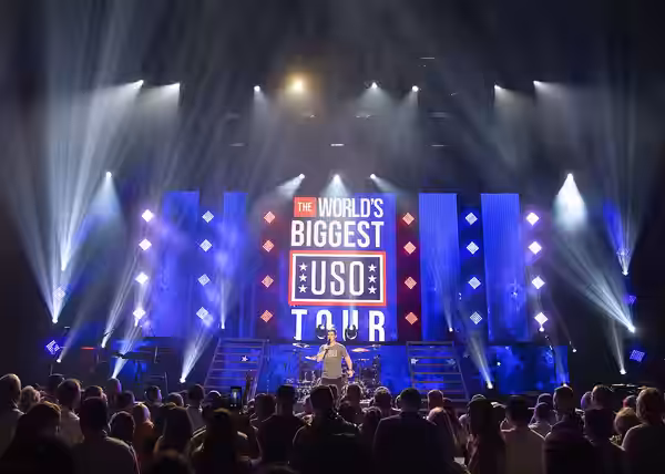 Comedian Adam Devine performs for service members attending in person and around the globe through streaming video at the World's Biggest USO Tour in Washington (2018)