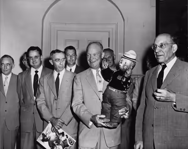 President Dwight Eisenhower holding a Smokey Bear doll at presentation. Washington, DC (Forest Service photo)