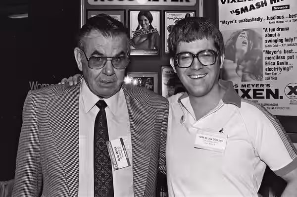 Film maker Russ Meyer with author Max Allan Collins at the 1982 Consumer Electronics Show at McCormick Place in Chicago