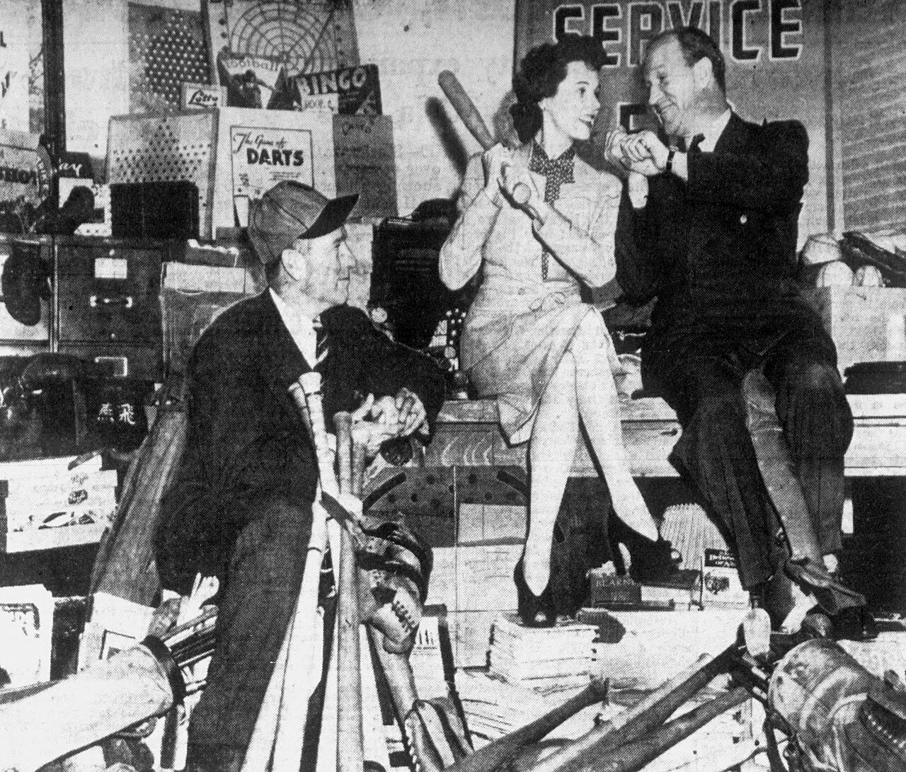 Hollywood Stars manager Charlie Root (left), actress Jane Wyatt (center) and Los Angeles Angels manager Bill Sweeney (right) sit atop a pile of baseball equipme (1943)