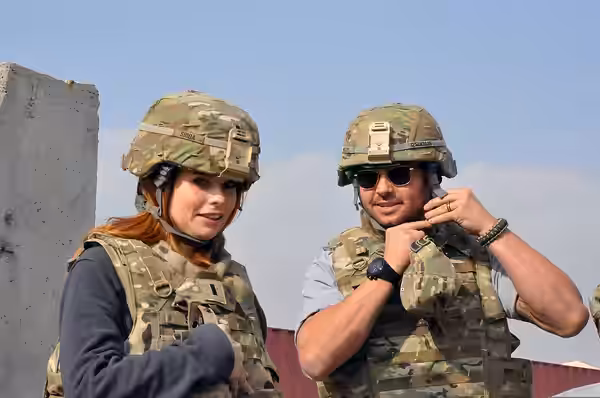 Actress JoAnna Garcia Swisher, left, and her husband, outfielder Nick Swisher, don armored vests and helmets before boarding a helicopter at Forward Operating B (2011)