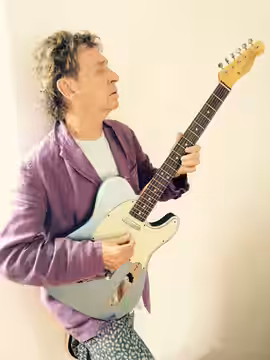 A portrait of Andy Summers with a guitar in 2015. Other information Cropped from the original image.