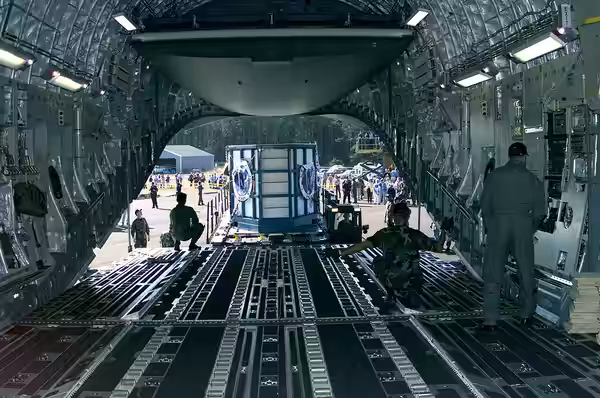 An Air Force C-17 Globemaster III loadmaster positions a 60K Tunner cargo loader behind the aircraft in preparation for loading the specially made transport tan
