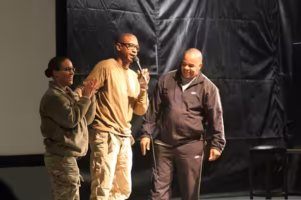 Comedian Tommy Davidson, center, recognizes U.S. Army Sgt. Natashia Hunter, left, a paralegal specialist with Headquarters and Headquarters Battalion, 4th Infan