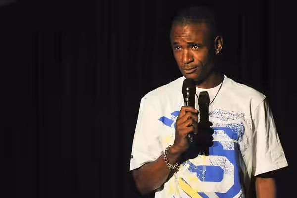 Mr. Tommy Davidson, comedian, performs on stage at Pete's Place for over 500 deployed military members August 26, 2010