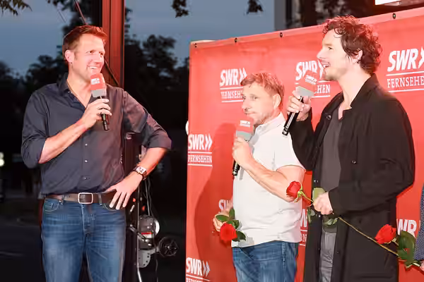 Jens Hübschen (links) interviewt die beiden Tatortkommissare Richy Müller (mitte) und Felix Klare (rechts). Das Foto entstand beim SWR Sommerfestival 2016 in Ma