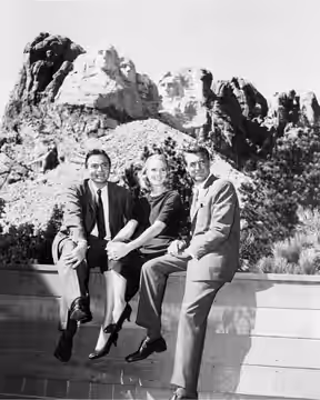 Photo of James Mason, Eva Marie Saint and Cary Grant, stars of the film North by Northwest posing at Mount Rushmore. From the trade magazine Motion Picture Dail