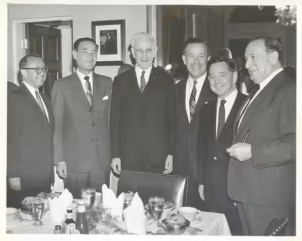 Black and white photograph print, from left to right: Leo Jaffe, executive vice president of Columbia Pictures Corp.; A. [Abraham] Schneider, Columbia President
