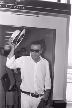 Collectie / Archief : Fotocollectie Anefo Reportage / Serie : [ onbekend ] Beschrijving : Eddie Constantine op Schiphol voor filmopnamen Geen paniek , zwaaiend  (1972)
