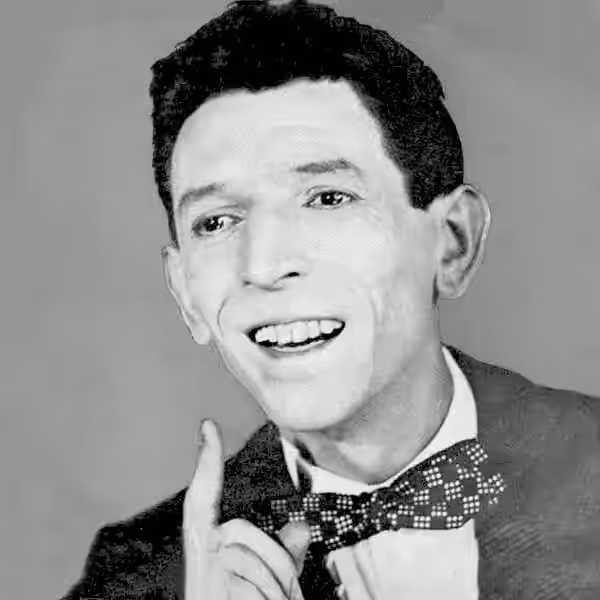 Pierre Repp pose légèrement penché sur sa droite, regardant dans la même direction, souriant et pointant l'index droit vers le haut. Il porte les cheveux noirs, (1953)