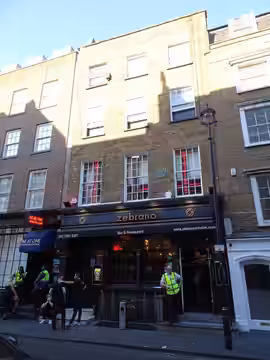 18 Greek Street London W1D 4DS. Peter Cook 1937-1995 comedian and "only twin" co-founded and ran the Establishment Club here 1961-1964 (2022)