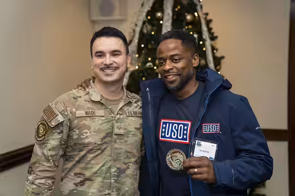 Actor Dulé Hill takes a photo with a U.S. Airmen during the 2023 USO Holidays Tour at RAF Lakenheath, December 11, 2023. For 82 years, the USO has helped connec