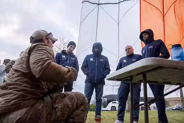USO performers and support staff learn about Survival, Evasion, Resistance, Evasion (SERE) tactics from U.S. Airmen during the 2023 USO Holidays Tour at RAF Lak
