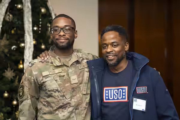 Actor Dulé Hill takes a photo with a U.S. Airmen during the 2023 USO Holidays Tour at RAF Lakenheath, December 11, 2023. For 82 years, the USO has helped connec