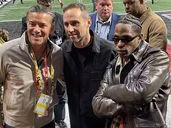 Cole Gahagan, President &amp; Chief Executive Officer, Michael Rubin, and Travis Scott on the sideline of Mercedes-Benz Stadium before the 2025 College Football