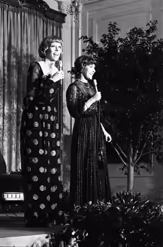 1976, January 27 – East Room – The White House – Washington, DC – Carol Burnett, Helen Reddy – standing on stage, singing – State Visit of Israeli Prime Ministe