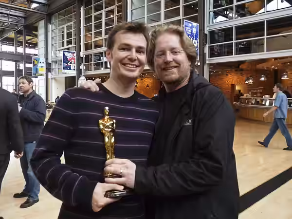 Andrew Stanton and Victor Navone holding an academy award (2009)