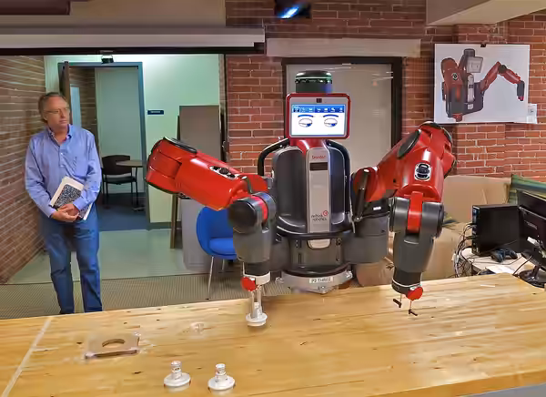 Rodney Brooks, the MIT robotics pioneer behind iRobot and now Rethink Robotics, looks proudly as Baxter manipulates objects on the table. Just moments before, w (2012)