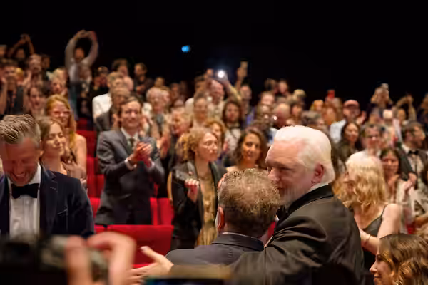 Julian Assange and Eugene Jarecki in the audience after the premiere of The Six Billion Dollar Man at the 2025 Cannes Film Festival