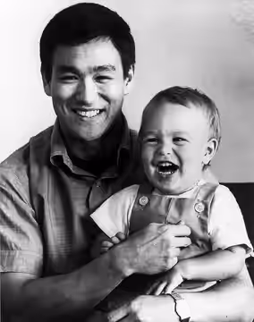 Publicity photo of Bruce Lee with son Brandon. Per source, the photo was accompanied by an original color press kit folder for Enter the Dragon." This is standa