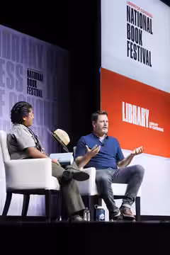 Nick Offerman discusses his recent book, "Where the Deer and the Antelope Play," with Millie Jimenez of the National Park Service at the 2022 National Book Fest