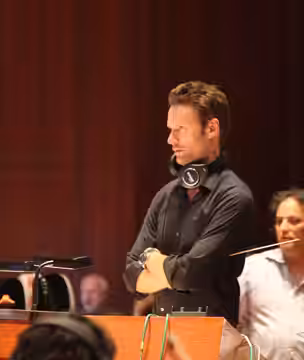 Brian Tyler on the podium conducting music