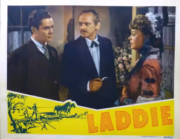 Lobby card for the American drama film Laddie (1940). Laddie (Tim Holt), Mr. Pryor (Miles Mander) and Pamela (Virginia Gilmore). At bottom right is Country of o