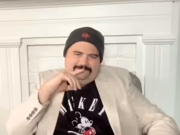 Actor Paul Walter Hauser sitting in an online interview to promote the Disney film "Cruella" in 2021.