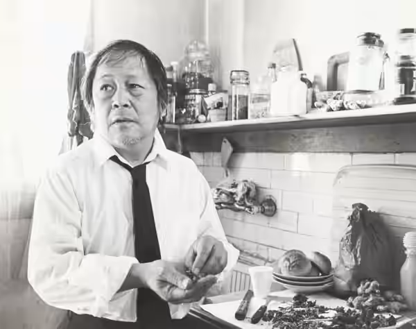 Actor Victor Wong thinking about what to make for dinner in an acquaintance's apartment in San Francisco, California 1983 Photo by Nancy Wong.