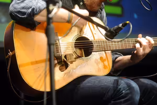 Glen Hansard's Takamine NP15 guitar, with a hole below the strings. Photo was taken during a concert at Lucca Comics &amp; Games 2015.