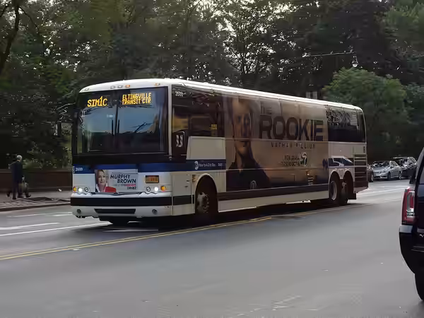 An Eltingville Transit Center-bound SIM1C express bus traveling west on 59th Street (Central Park South) towards 7th Avenue in Midtown Manhattan. The SIM1C is t