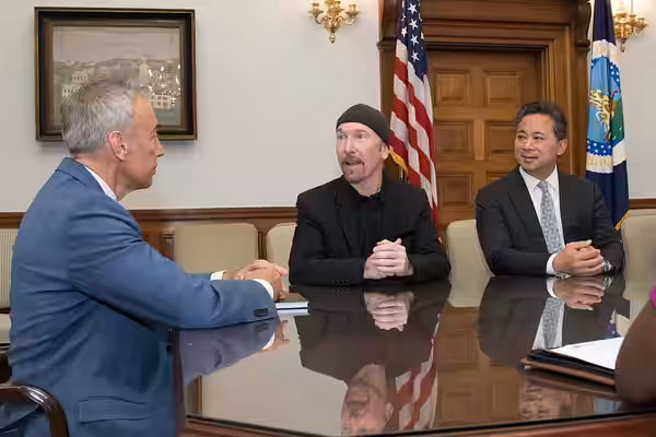 U.S. Department of Agriculture Deputy Secretary Steve Censky, blue coat, welcomes U2 guitarist and Angiogenesis Foundation board member The Edge, black cap, and