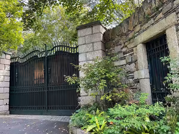 View coming up narrow and exclusive Vico Road in Killiney, a southern suburb of Dublin, Ireland, of the gates to the home of singer-songwriter Bono of U2 and hi (2023)