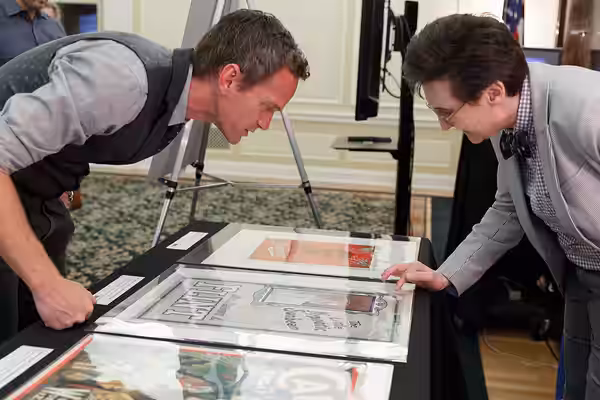 Neil Patrick Harris looks through a display of Harry Houdini Collection items with Janice Grenci of the Prints and Photographs Division in the Whittall Pavilion (2019)