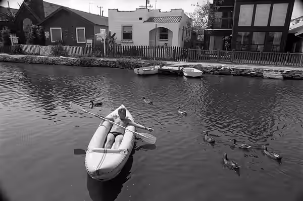 Actor Orson Bean in a kayak on the Carroll Canal in Venice, California, with ducks (1984)