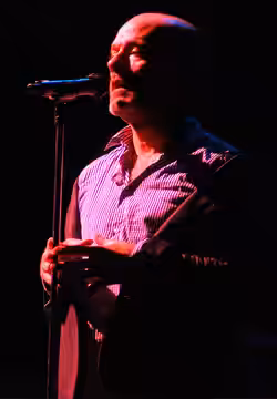 Michael Stipe of the band, R.E.M. has decided to wear his jacket "off the shoulder" and has even taken his ear-piece out, very casual indeed! Taken at the Lanca (2008)