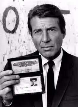 Photo of Efrem Zimbalist, Jr. as Lewis Erskine, displaying his FBI credentials from the television program The FBI. (1969)