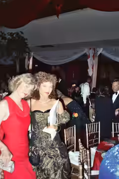 Amy Irving poses with unidentified woman in red at the Governor's Ball following the telecast of the 61st Annual Academy Awards, 1989. Mike Ovitz can be seen at