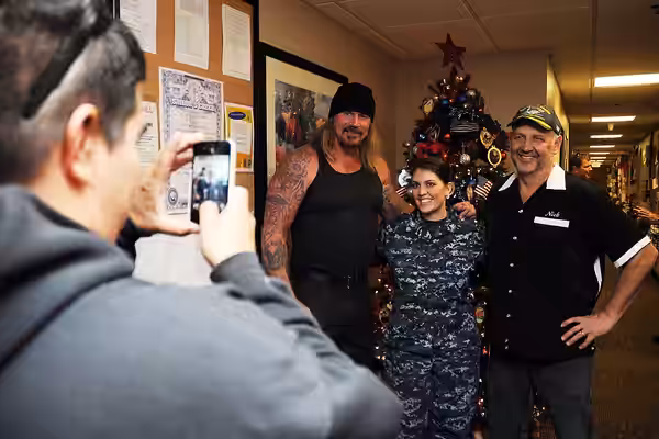 Actors Rusty Coones, left, from "Sons of Anarchy" and Nick Searcy, from "Justified" pose for a photo with Boatswain's Mate 3rd Class Ashton Weig during a morale (2013)