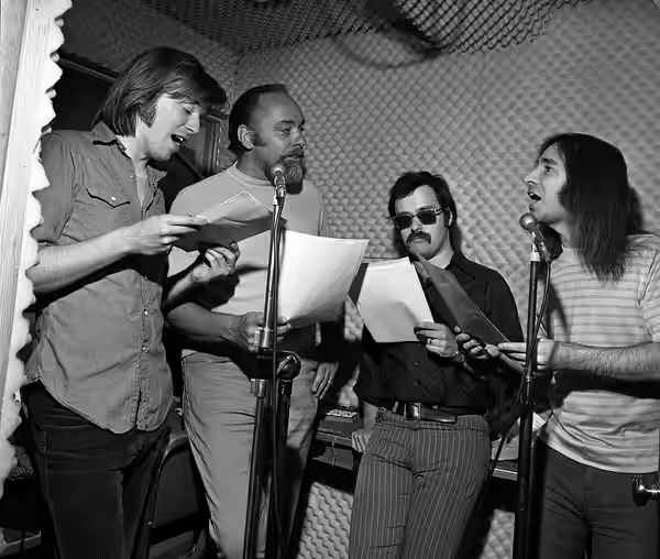 Members of the satirical comedy team, The Credibility Gap, performing in a radio station sound room in Los Angeles. From left: Michael McKean, Richard Beebe, Da (1970)