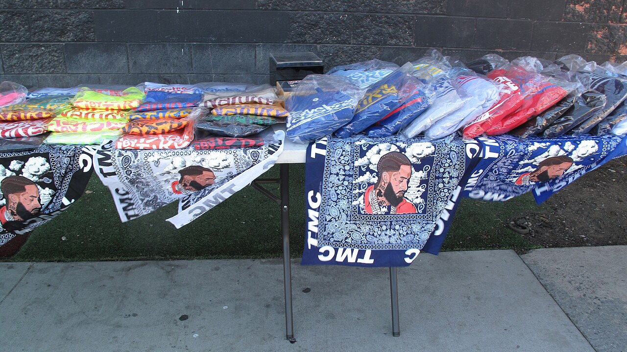 Fabrics with picture of Nipsey Hussle, for sale near his (closed) restaurant next to the corner of Crenshaw and Slauson, Los Angeles (2022)