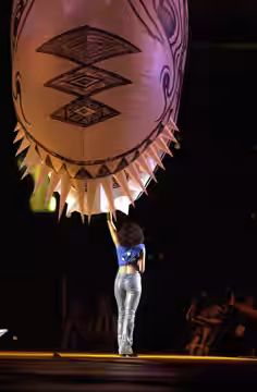 Australian aboriginal singer Christine Anu performs at the 2000 Sydney Paralympic Games Opening Ceremony. A float in the shape of a creature with spikes hovers 