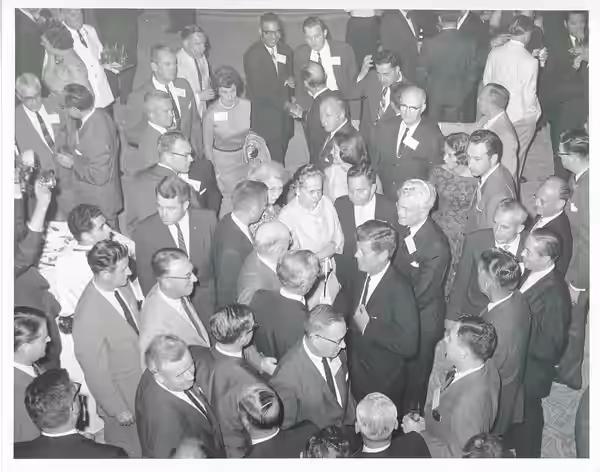 Black and white photograph print of Carl Albert and John F. Kennedy standing in the middle of a large crowd.