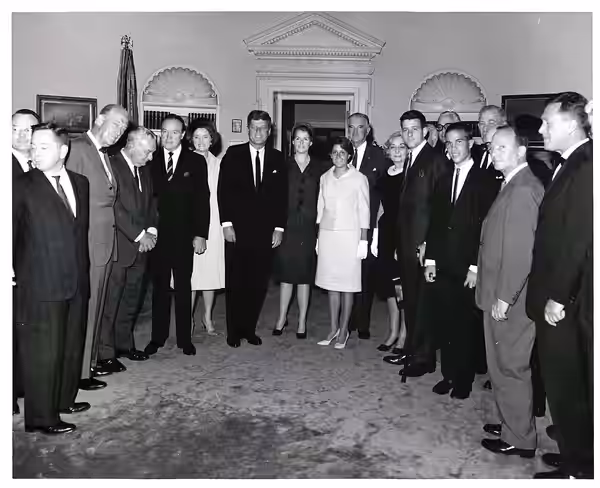 Carl Albert, Les Arends, Charles Halleck, Bob Hope, Dolores Hope, and John F. Kennedy posing with a large group of people.