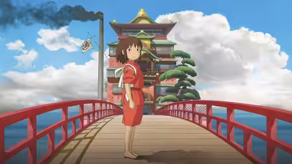 Chihiro standing on a red bridge facing the bathhouse